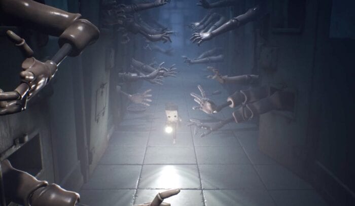 Mono running down a hall filled with arms grabbing in Little Nightmares 2