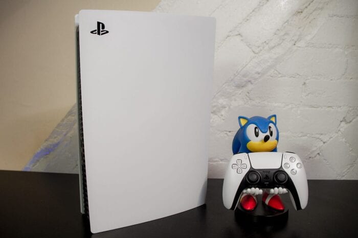 A photo of the PlayStation 5 with a Sonic the Hedgehog figure holding the DualSense controller.